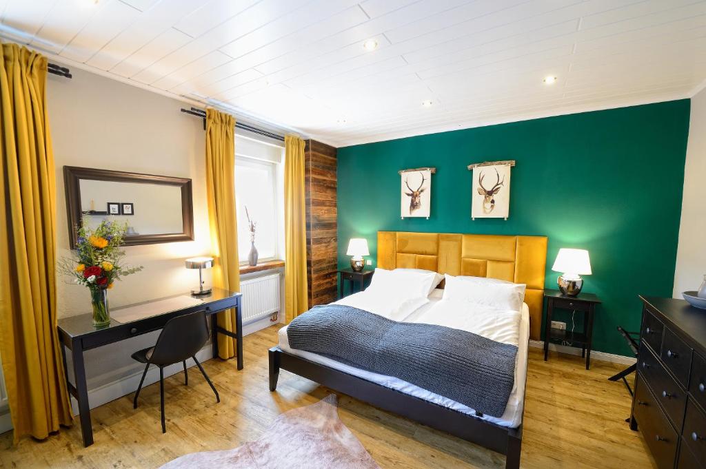 - une chambre avec des murs verts, un lit et un bureau dans l'établissement Chalet-Apartement in ehemaliger Hofraite, à Bruchköbel