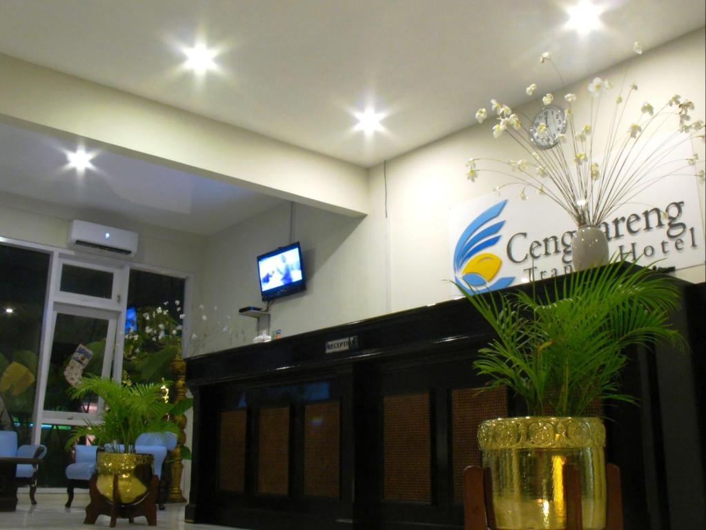 a lobby with a tv and a vase with flowers at Cengkareng Transit Hotel in Tangerang