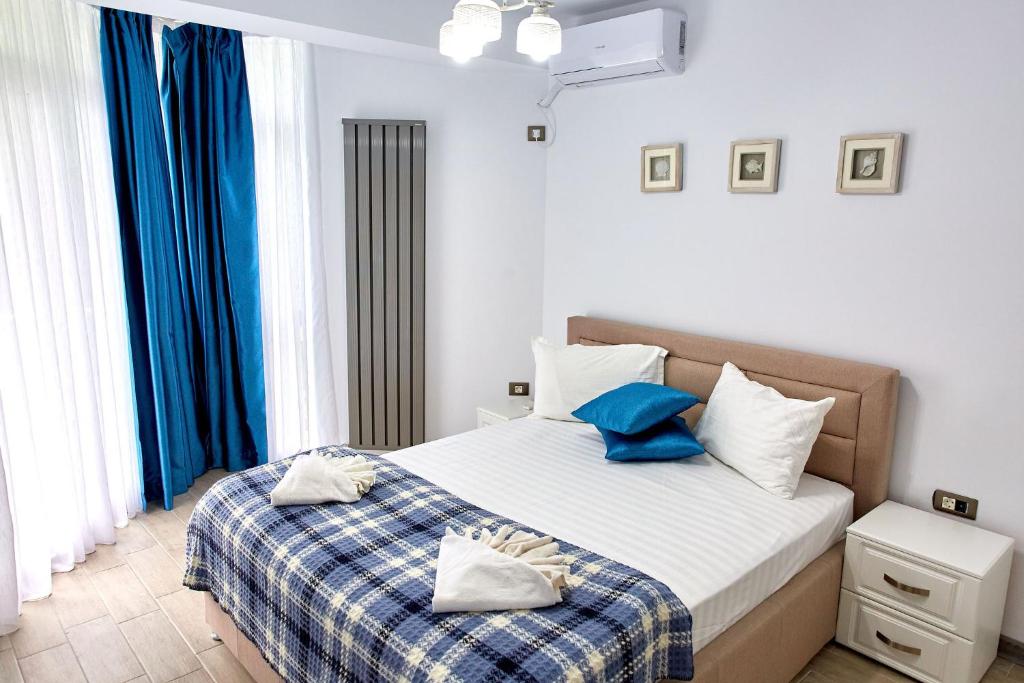 a bedroom with a bed with blue and white pillows at Apartament Atlantis by ALZ in Mamaia Nord