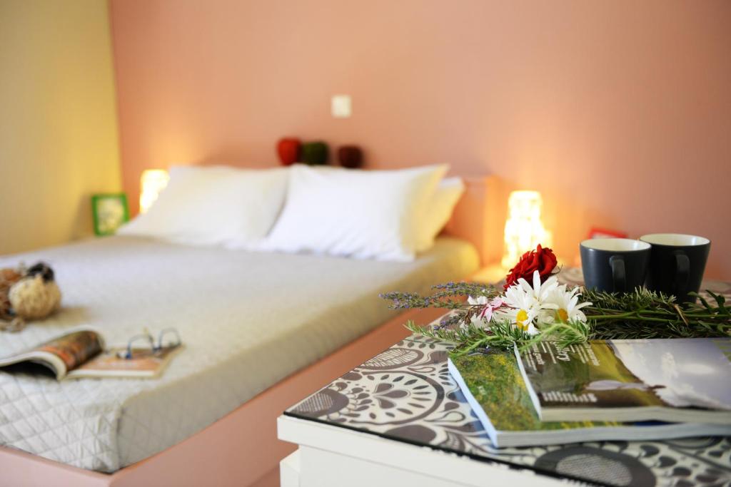 - une chambre avec un lit et une table fleurie dans l'établissement Esperides, à Marathopolis