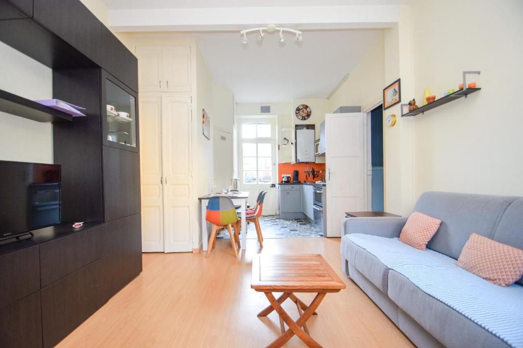 un salon avec un canapé et une table dans l'établissement Appartement 6 pers a 300m de la plage du prieuré, à Dinard