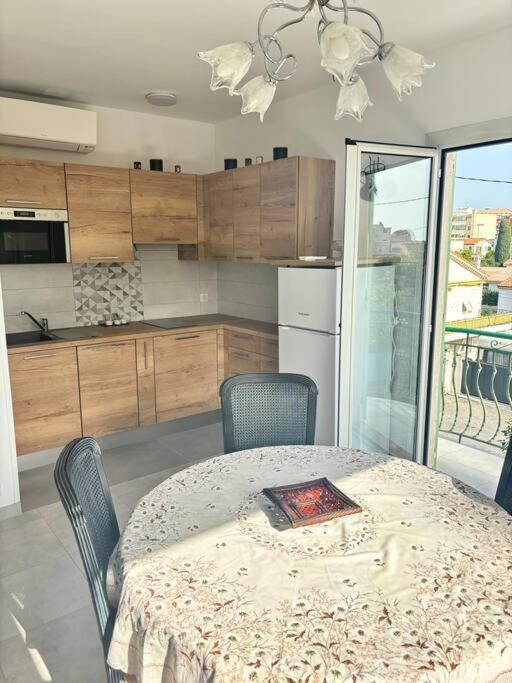 une cuisine avec une table et des chaises ainsi qu'une cuisine avec une table et une table dans l'établissement Charmant T3 Rénové Proche Mer, Aéroport et Gare !, à Saint-Laurent-du-Var