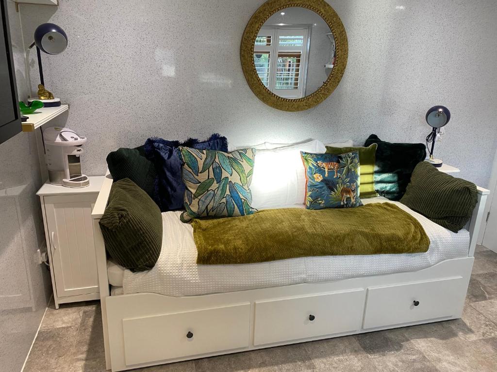 Cama en habitación con espejo en Oakwood Cabin Retreat in Bexleyheath, en Kent