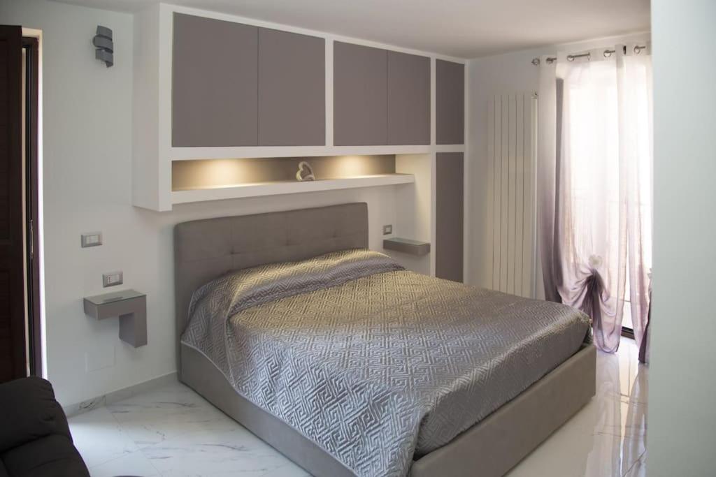 a white bedroom with a bed and a window at Mono Relax - Borgo Medioevale Petruro Irpino AV in Petruro Irpino