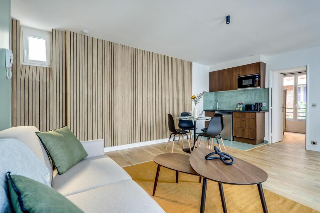 un salon avec un canapé et une table dans l'établissement Heart of Montmartre l Sacré-Coeur at 10min, à Paris