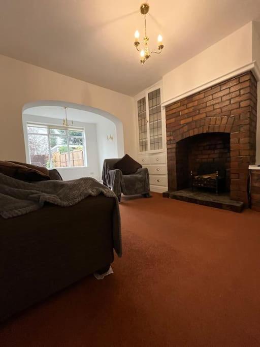 a living room with a couch and a fireplace at West Street House-Furnished Let in Hoyland Nether
