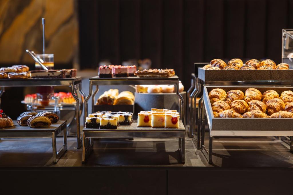 una vetrina con vari dolci e altri prodotti da forno di Hi Hotels Trento - Wellness & Spa Adults Only a Trento