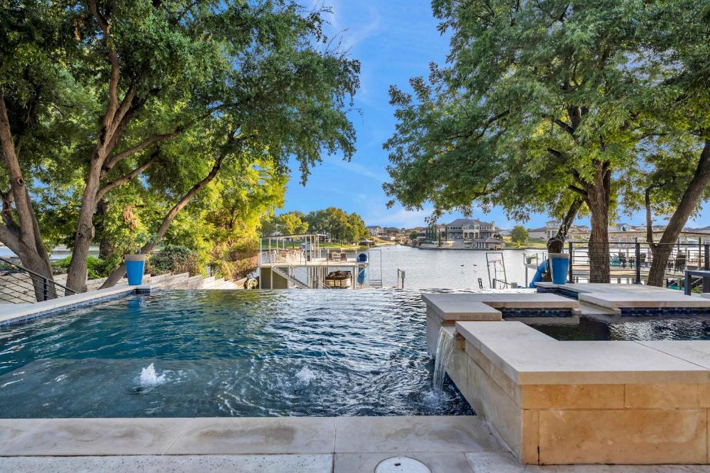 a swimming pool with trees and a body of water at Lakeshore Retreat with Concierge Services in Kingsland
