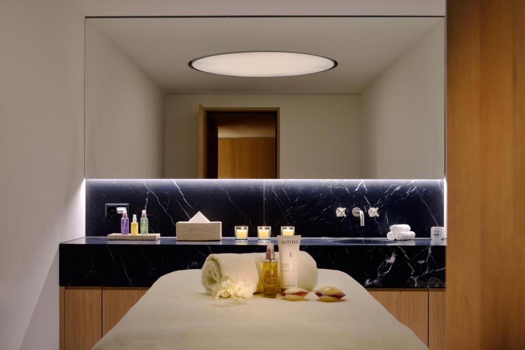 a bathroom with a counter with a table and a mirror at Crystal Hotel superior in St. Moritz