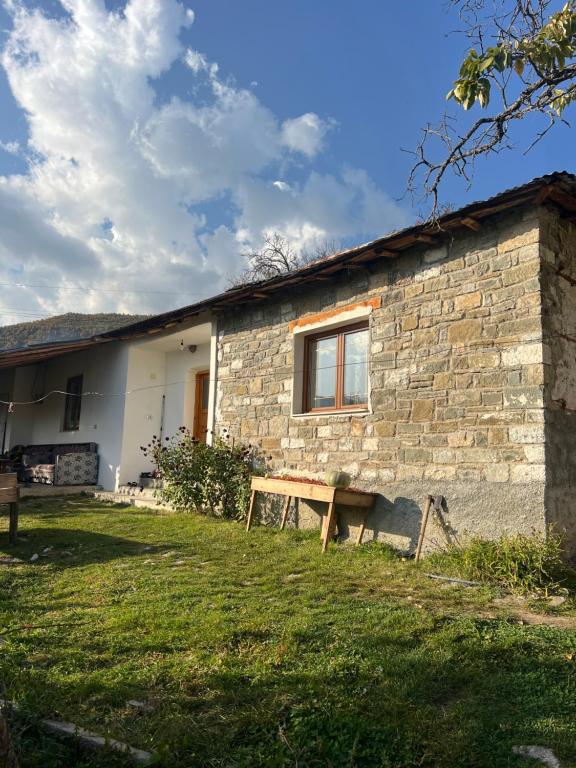 una casa de piedra con un banco delante en Peto House, en Strelcë
