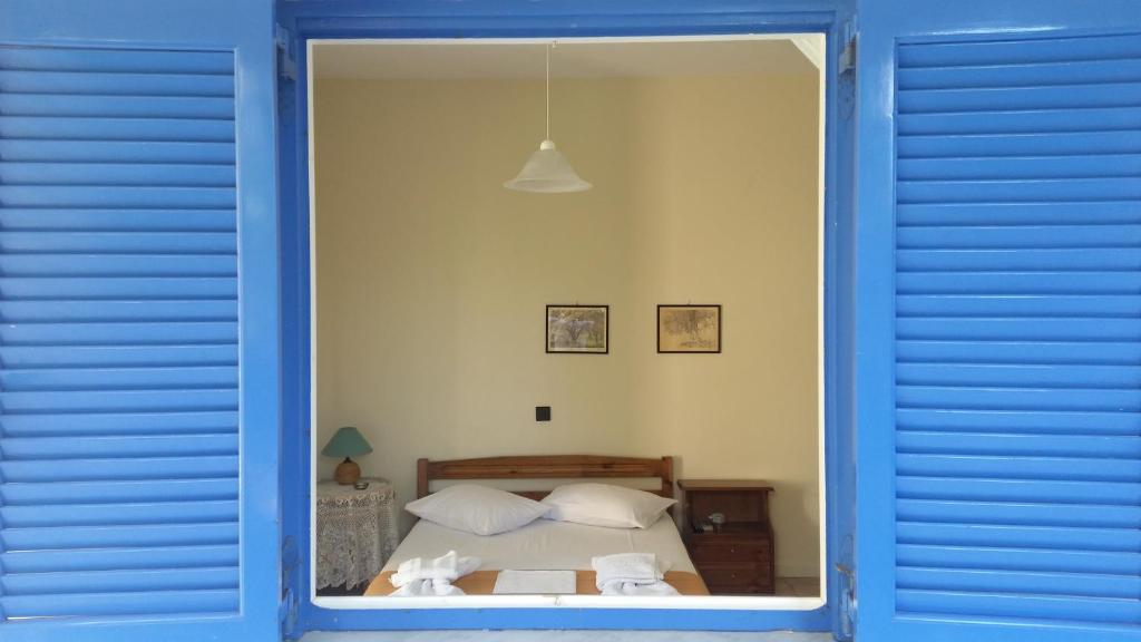 a bedroom with a bed through a blue window at Fraxa in Lygia