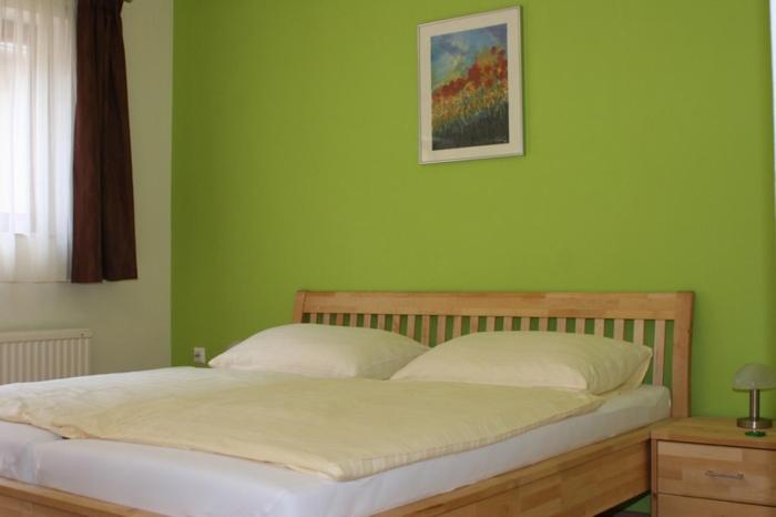 ein Schlafzimmer mit einem Bett mit einer grünen Wand in der Unterkunft Erbhof Wegleitner in Illmitz