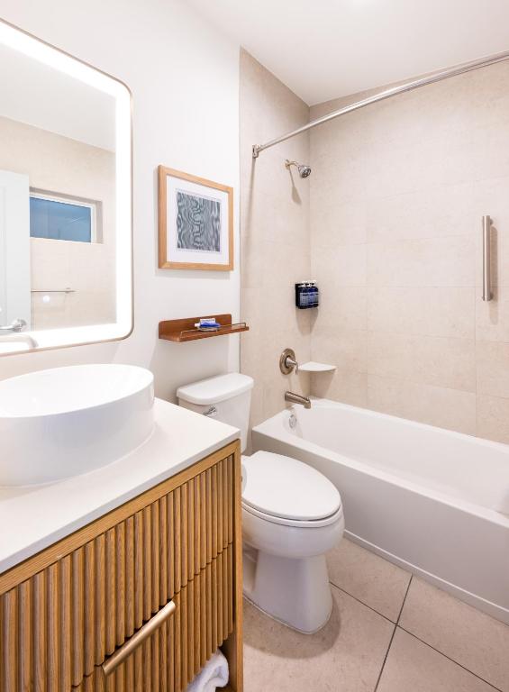 a bathroom with a sink and a toilet and a tub at Islander Resort in Islamorada