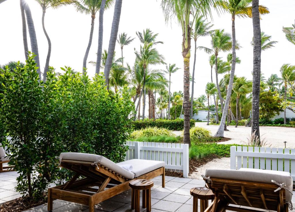 a patio with two chairs and palm trees at Islander Resort in Islamorada