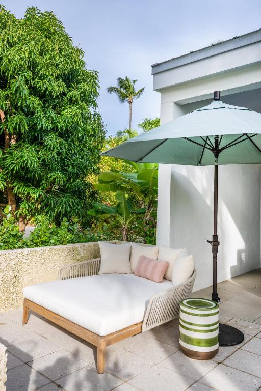 a white couch sitting under an umbrella on a patio at Islander Resort in Islamorada