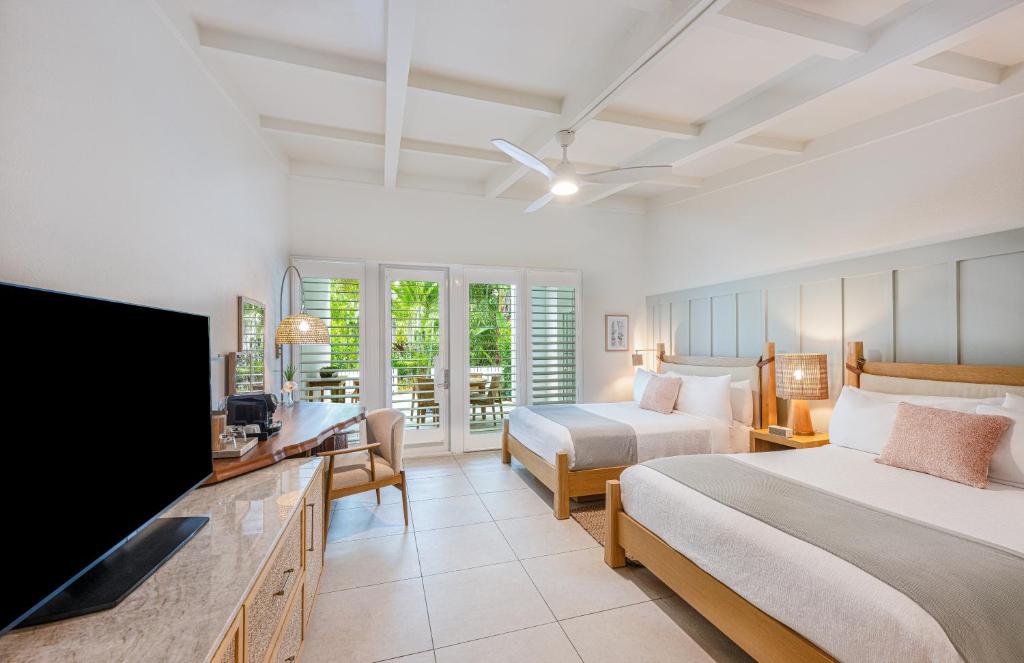 a bedroom with two beds and a flat screen tv at Islander Resort in Islamorada