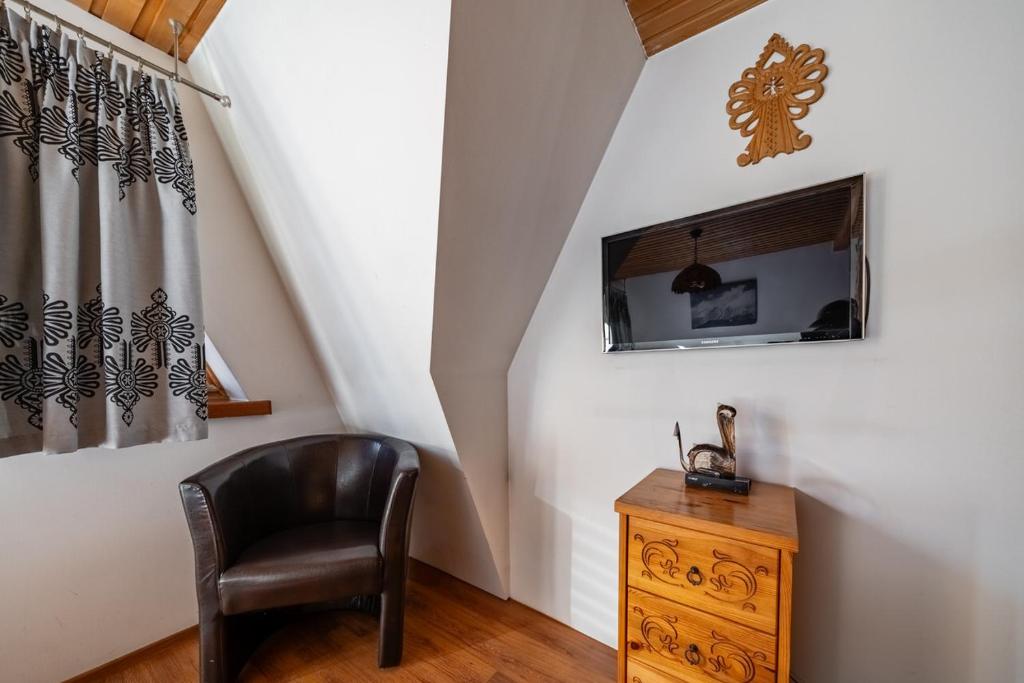 Televízia a/alebo spoločenská miestnosť v ubytovaní Domek Pod Strzechą