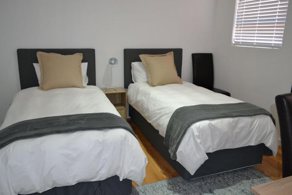 two beds sitting next to each other in a room at 4 Kiaat Suites in Klerksdorp