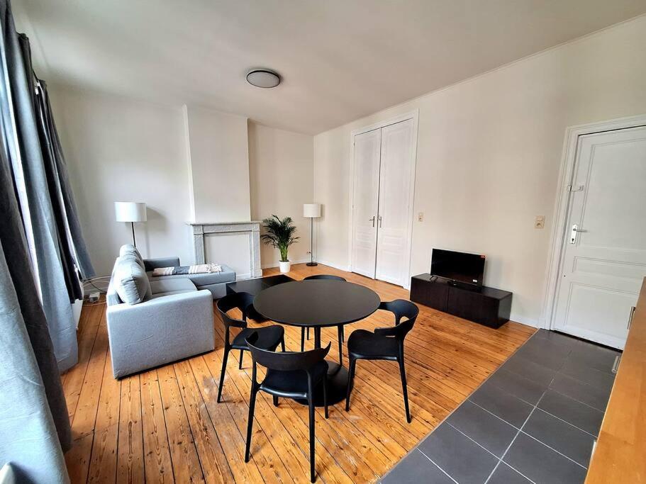 a living room with a table and chairs and a couch at La Suite Alice in Brussels