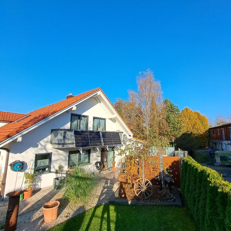 a white house with a balcony and a yard at Ferienwohnung Ludwigshöhe in Kempten