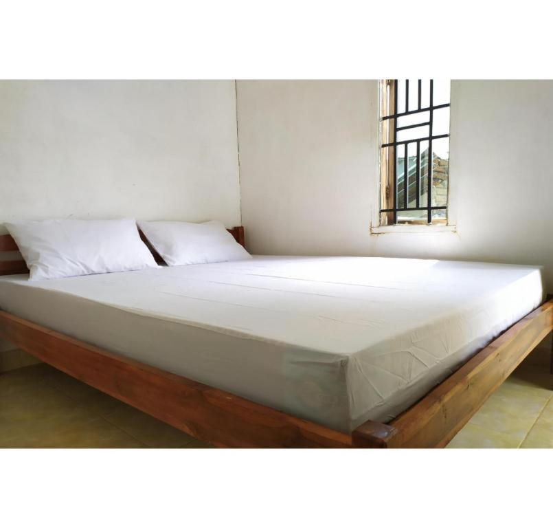 a large bed in a room with a window at Hotel O Bontotangnga Homestay in Balangberu