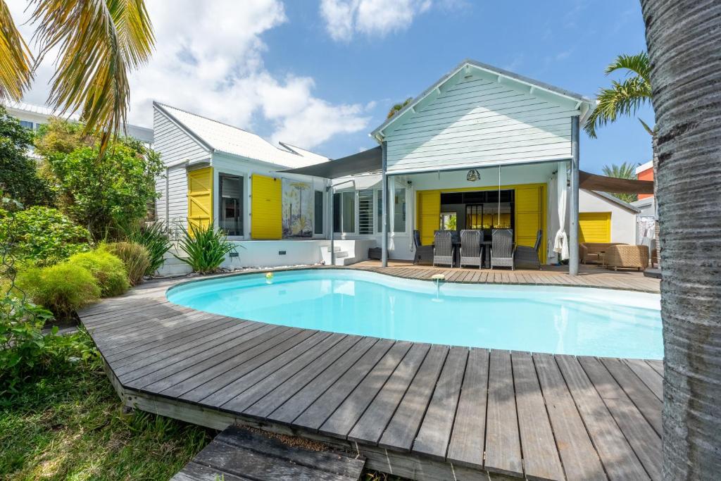 a home with a swimming pool and a house at Villa Ylang - Piscine et Jacuzzi in La Saline les Bains