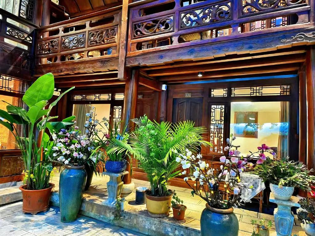 a bunch of potted plants in front of a building at 原乡文苑客栈 in Lijiang