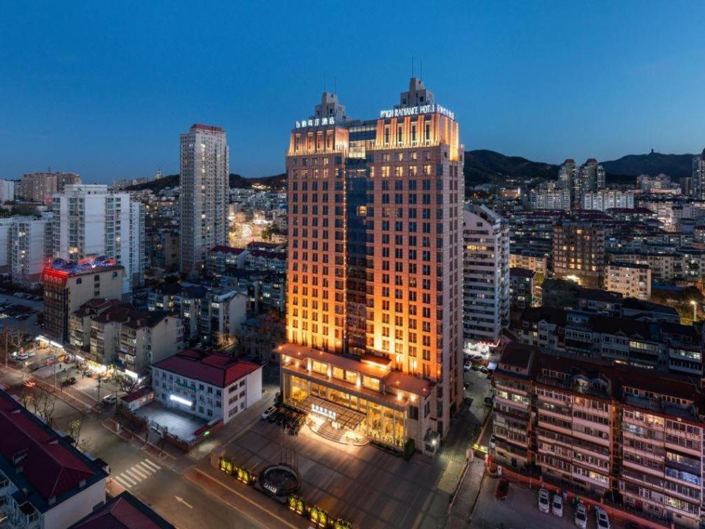 a lit up building in a city at night at Brigh Radiance Hotel Yantai in Yantai