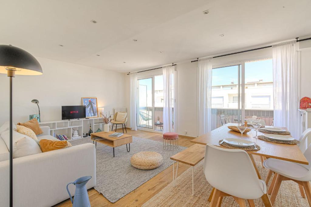 un salon avec un canapé blanc et une table dans l'établissement Charmant et Spacieux avec vue à 1 min de Tête d'Or, à Lyon