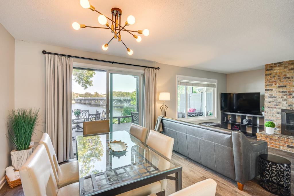 a living room with a couch and a table at Riverfront Champlin Townhome w/ Deck & Water View! in Champlin