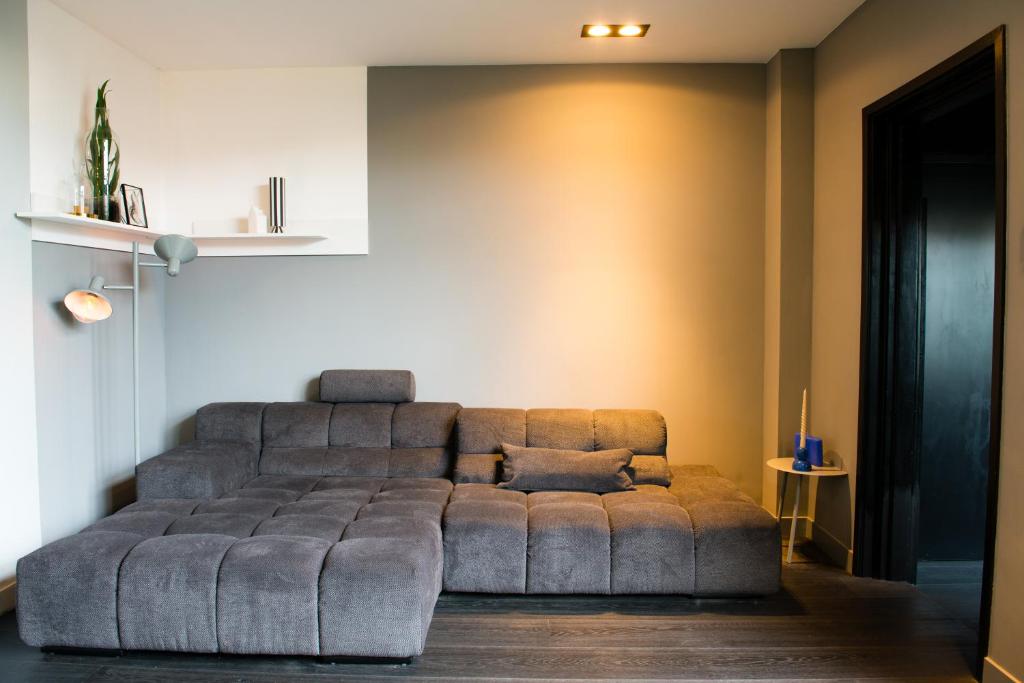 a living room with a couch in a room at Bijzonder stadshuis met diepe moderne tuin. in Alphen aan den Rijn