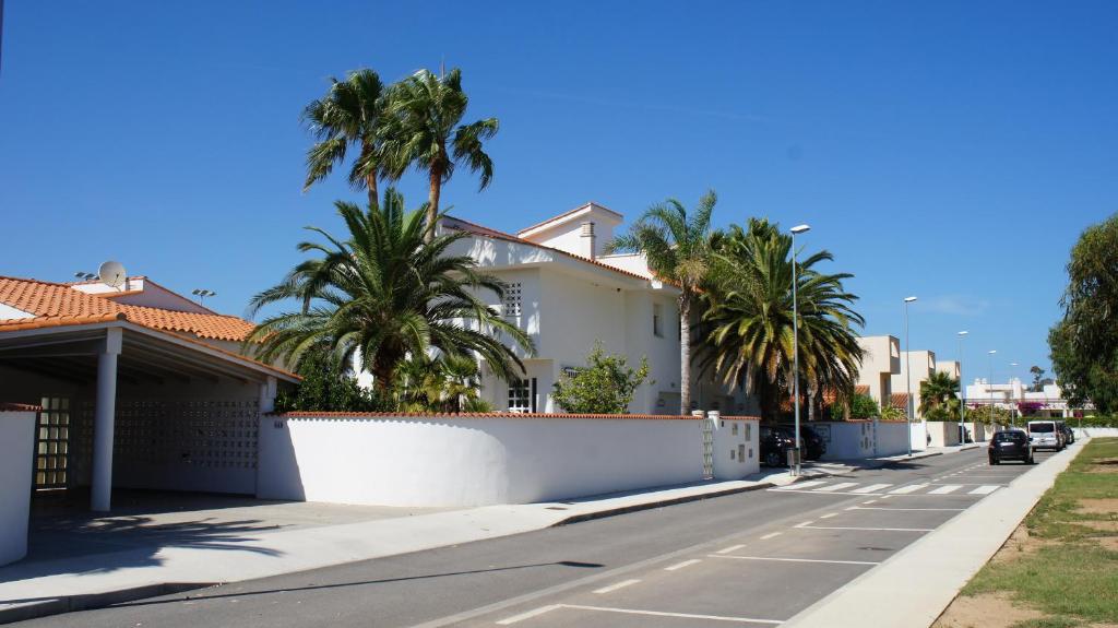 a house with palm trees on the side of a street at Apartment Los Eucaliptus in L'Eucaliptus
