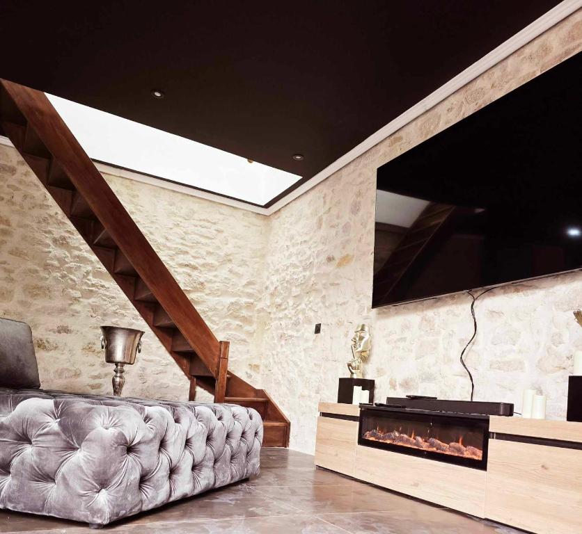 un salon avec un canapé et une cheminée dans l'établissement Le Royal Love Loft, à Reignac