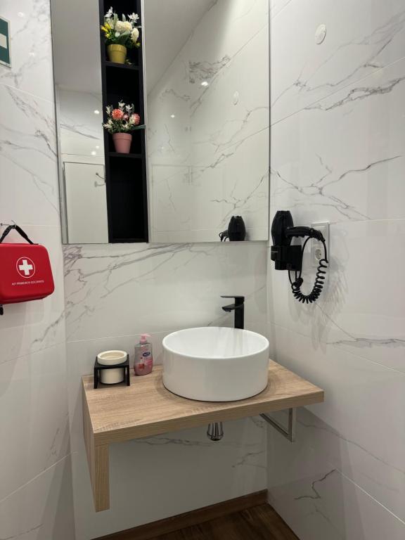 a white bathroom with a sink and a mirror at O Cantinho do Colégio - Dourocollege in Lamego