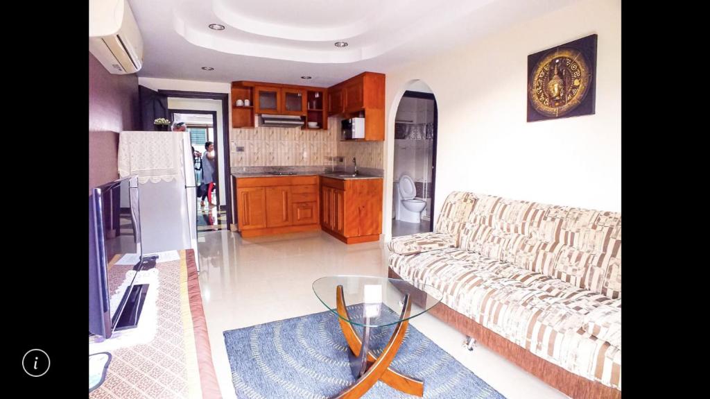 a living room with a couch and a glass table at Junior apartment in Pattaya