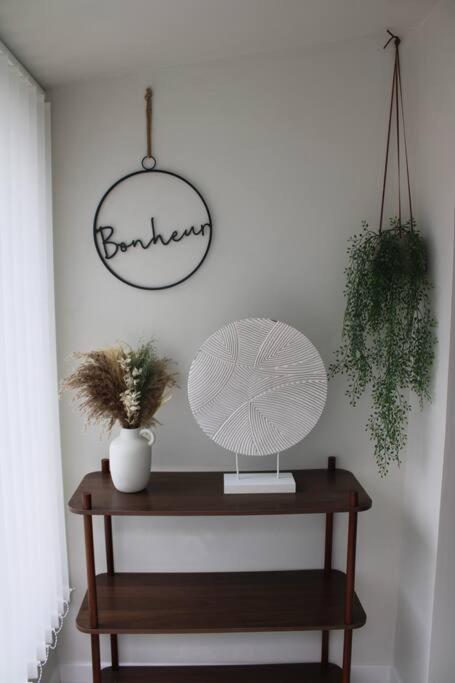 une table avec une lampe et un panneau sur un mur dans l'établissement La Cachette du Bonheur, à Cély-en-Bière