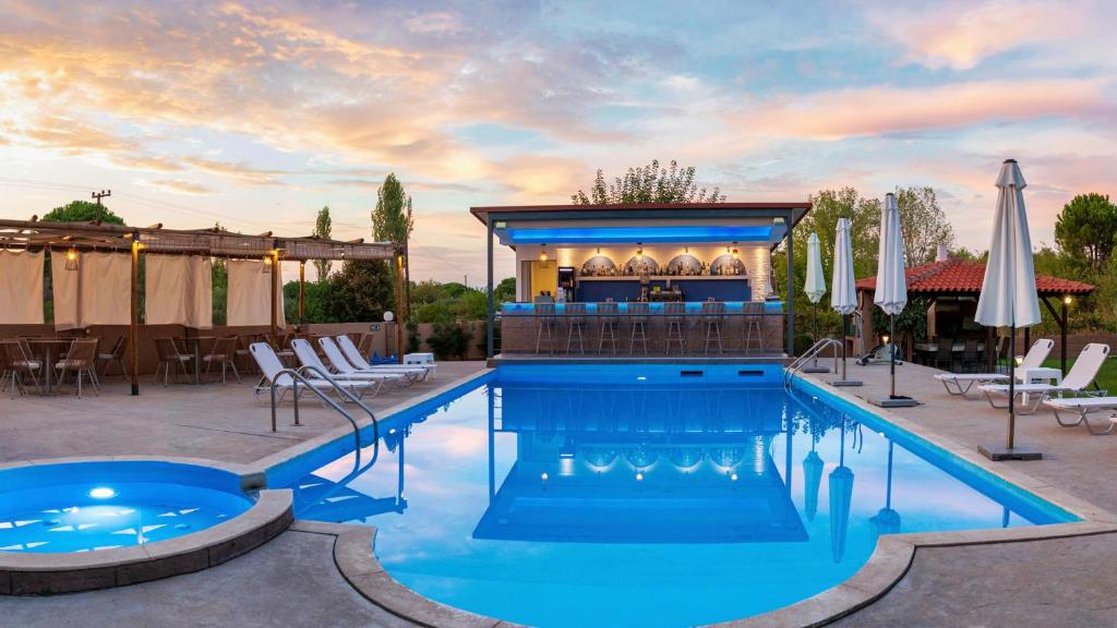 a pool at a hotel with a bar and chairs at Katerina-Maria Studios & Apartments in Vourvourou