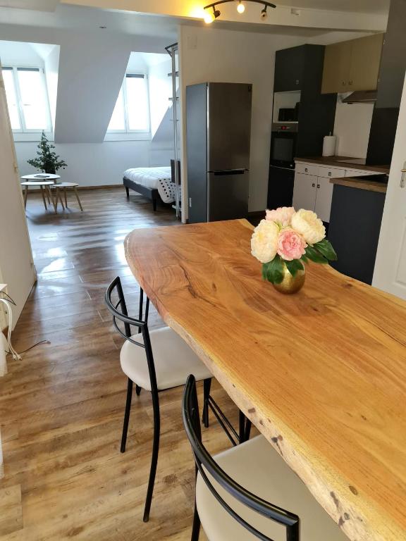 une table en bois avec un vase de fleurs dessus dans l'établissement genie 2, à Mézières-Charleville