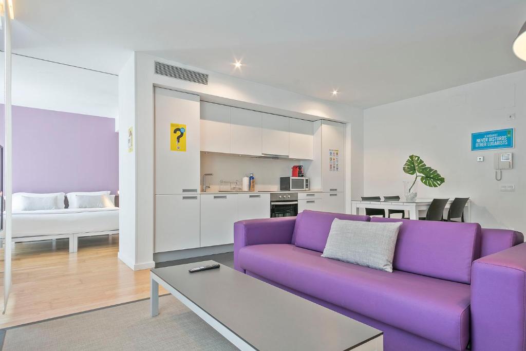 Una sala de estar con un sofá morado y una mesa. en Lugaris Beach Apartments, en Barcelona