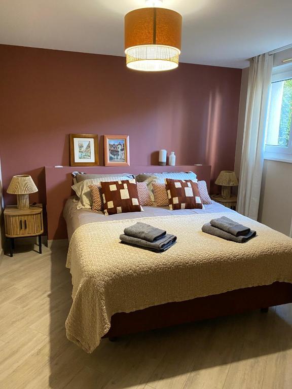 une chambre avec un grand lit avec des serviettes dessus dans l'établissement Au chemin des vignes, à Bergheim