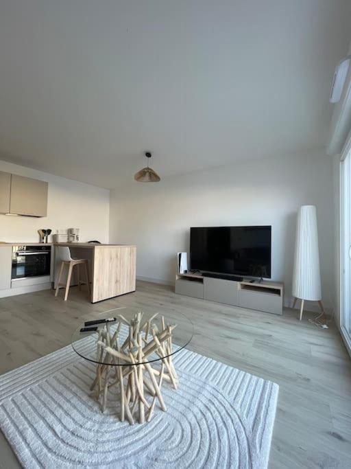 un salon avec une table et une télévision dans l'établissement Appartement belle escale, à Dunkerque