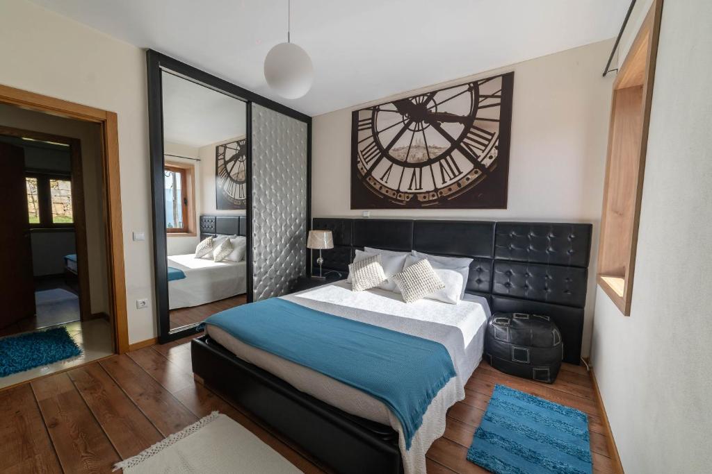 a bedroom with a bed and a large clock on the wall at Casa do Casal do Douro in Marco de Canavezes