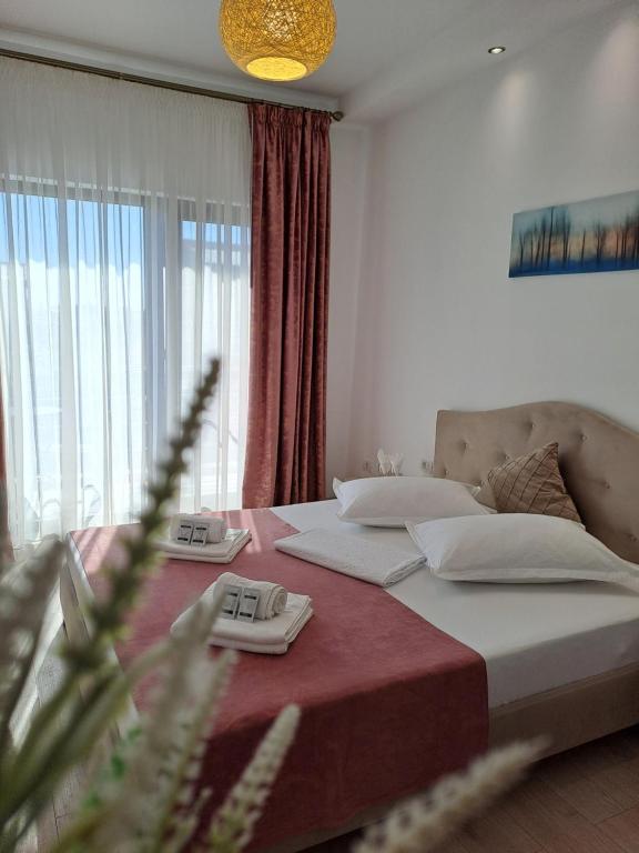 a bedroom with a bed and a large window at Casa Constantin Vic in Eforie Nord