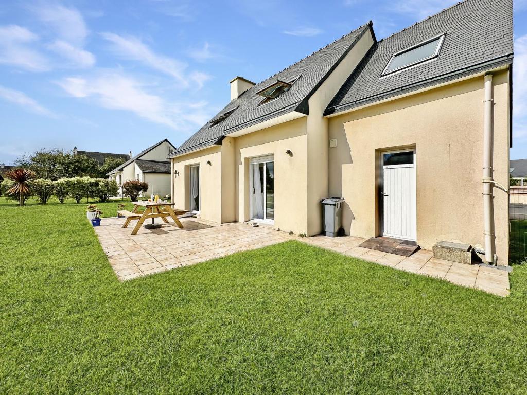 une maison avec une table de pique-nique dans la cour dans l'établissement Lagadenn jolie maison T4 terrasse jardin clos, à Plozévet