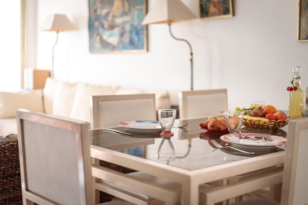 une table de salle à manger avec un bol de fruits dessus dans l'établissement Suite Sandra - Appartement de luxe, à Cannes
