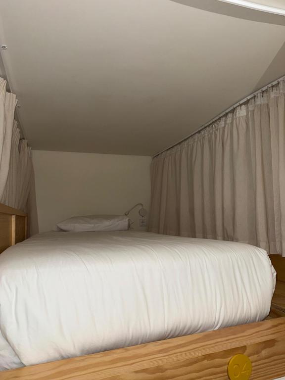 a white bed in a room with a window at Surf & Sea Suites in Parede