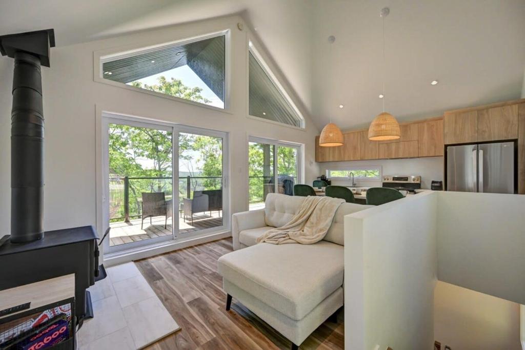 a living room with a couch and a kitchen at Le Petit Bijou in Sainte Béatrix