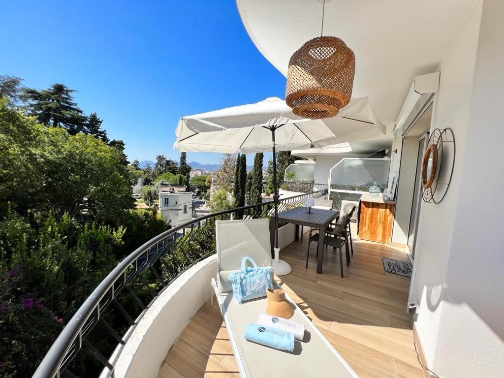 - un balcon d'une maison avec une table et un parasol dans l'établissement Appartement Cannes cosy vue mer, à Cannes