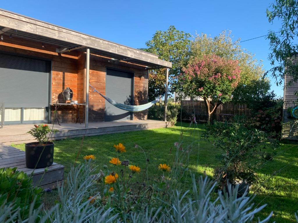 a house with a hammock in the yard at Chambres d'hôtes de Cécile in Notre-Dame-dʼAllençon