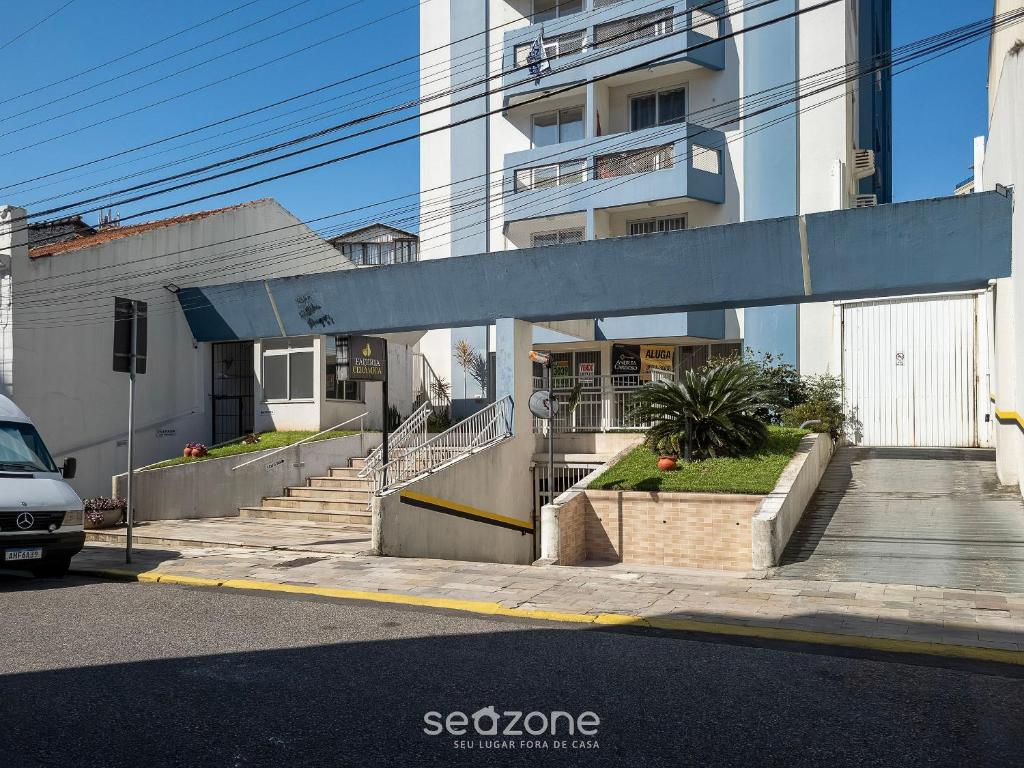 a white building with stairs and a building at EVAs - Apartamentos charmosos com vista mar em Floripa in Florianópolis